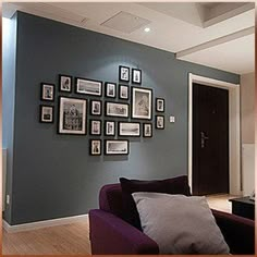 a living room filled with furniture and framed pictures on the wall above it's doorway