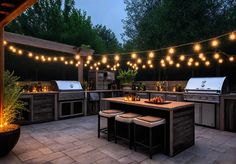 an outdoor kitchen with lights strung over it