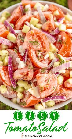 a salad with tomatoes, onions and cucumbers in a white bowl on the grass