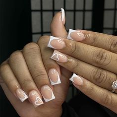 a woman's hands with french manies and white nail designs on their nails