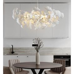 a modern chandelier hanging over a dining room table