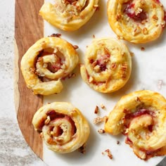 several pastries on a white plate sitting on a wooden cutting board