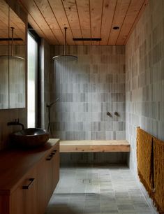 a bathroom with a wooden ceiling and tiled walls