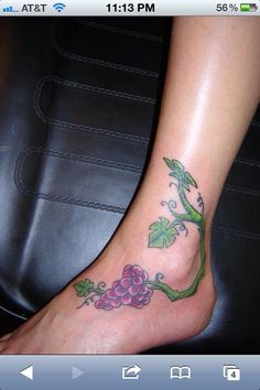 a woman's foot with a vine and flowers tattoo on her left side leg