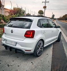 a white volkswagen car parked on the side of the road