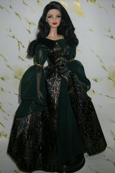 the doll is wearing a black and gold dress