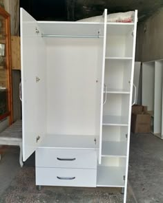 a white wardrobe with drawers and shelves in a room that is being renovated by someone