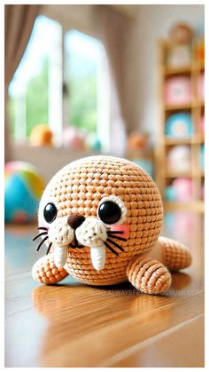 a crocheted cat sitting on top of a wooden floor