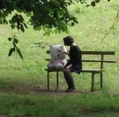 a person sitting on a bench with a stuffed animal