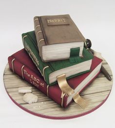 a cake made to look like three books stacked on top of each other with a graduation cap and tassel