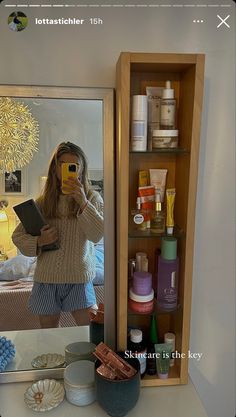 a woman taking a selfie in front of a mirror while holding a cell phone