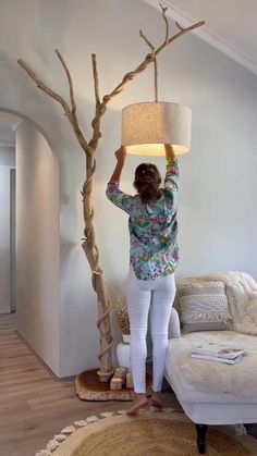 a woman standing next to a tree with a lamp on it