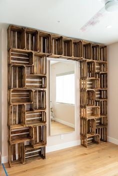 a large wooden book shelf sitting on top of a hard wood floor next to a mirror