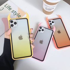 three iphone cases are sitting on a table next to a coffee cup and a drink