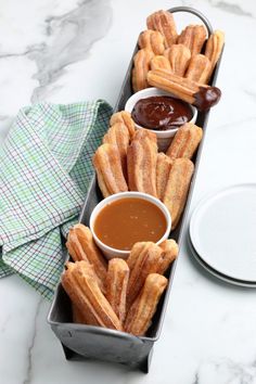 two trays filled with churro fries and dipping sauce