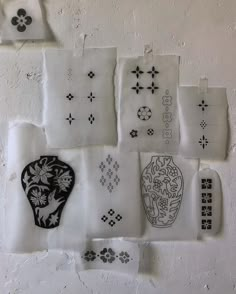 a bunch of different types of paper on a wall with flowers and vases drawn on them