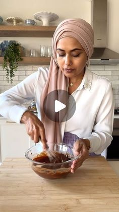 a woman in a headscarf is mixing something in a bowl