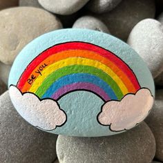 a painted rock with a rainbow on it