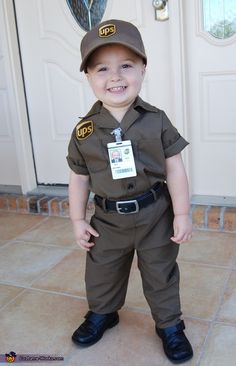 a little boy dressed up as a police officer in front of a door wearing a hat and uniform