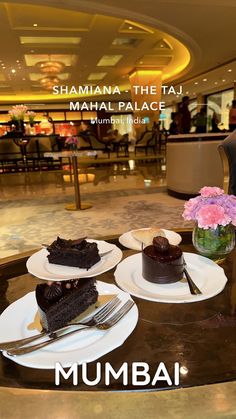 there are three pieces of chocolate cake on the table with flowers in front of them