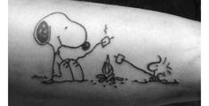 a man's arm with a drawing of a dog and a person digging in the ground