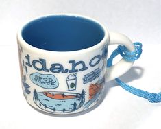 a blue and white coffee mug sitting on top of a table next to a rope