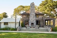 a house with a stone fireplace in the front yard