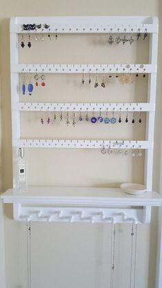 there is a white shelf with earrings on it