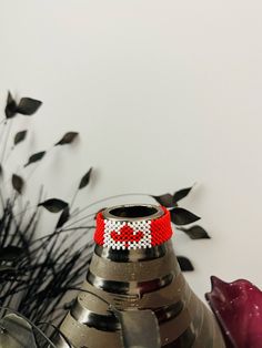 The Canadian flag bracelet, an Afrocrafted piece, is made with glass beads intricately handwoven to mirror the red and white colours of the national flag, featuring a red maple leaf. The thread used in its construction is water-resistant, woven with strong, non-elastic material that ensures durability and resistance to breaking.   𝐓𝐡𝐞 𝐬𝐢𝐳𝐞 𝐨𝐟 𝐭𝐡𝐞 𝐛𝐫𝐚𝐜𝐞𝐥𝐞𝐭 𝐢𝐬 𝐝𝐞𝐭𝐞𝐫𝐦𝐢𝐧𝐞𝐝 𝐛𝐲 𝐭𝐡𝐞 𝐜𝐢𝐫𝐜𝐮𝐦𝐟𝐞𝐫𝐞𝐧𝐜𝐞 𝐨𝐟 𝐢𝐭𝐬 𝐢𝐧𝐧𝐞𝐫 𝐩𝐚𝐫𝐭. 𝐓𝐨 𝐟𝐢𝐧𝐝 𝐲𝐨𝐮𝐫 ? Flag Bracelet, Red Maple Leaf, Canadian Flag, Red Maple, National Flag, Canada Flag, Maple Leaf, Personalized Birthday, The National