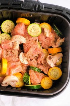 a container filled with meat and veggies on top of a white tablecloth