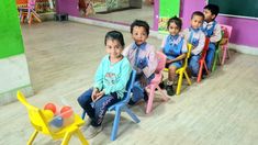 several children sitting in chairs and one is holding a toy