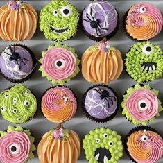 cupcakes decorated with colorful icing and halloween decorations are arranged in the shape of pumpkins