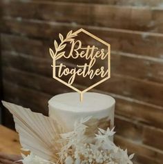 a wedding cake with a wooden sign that says better together