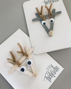 two reindeer made out of construction paper on top of a white piece of paper with googly eyes