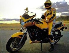 a man sitting on top of a yellow motorcycle