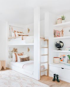 a white bedroom with bunk beds and bookshelves