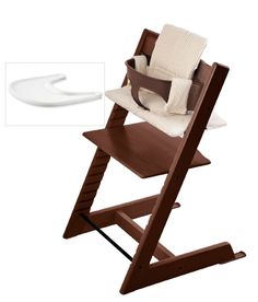 a wooden high chair next to a white object