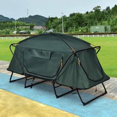 a large tent sitting on top of a wooden platform in front of a green field