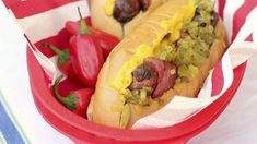 two hot dogs with toppings in a red basket