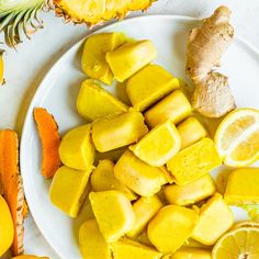 sliced up pineapples on a white plate next to some cut up oranges