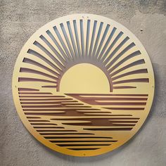 a circular metal sign with the sun rising over a mountain range on it's side