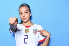 a woman pointing at the camera with her finger in front of her and wearing a usa jersey