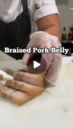 a person cutting up meat on top of a white counter