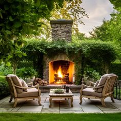 an outdoor fireplace with two chairs and a coffee table in the foreground, surrounded by greenery