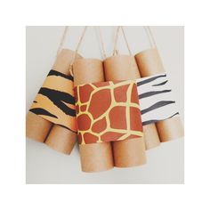 several rolls of toilet paper with giraffes and zebra print on them hanging from twine