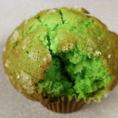 a green muffin with a bite taken out of it's center, on a white surface