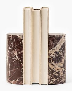 three books stacked on top of each other with marbled pages in the middle and bottom