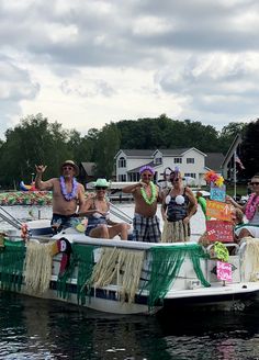 some people are sitting on a boat in the water and one person is holding a sign