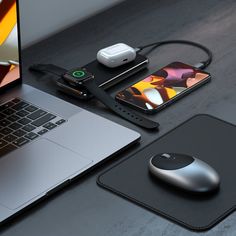 an open laptop computer sitting on top of a desk next to a mouse and cell phone