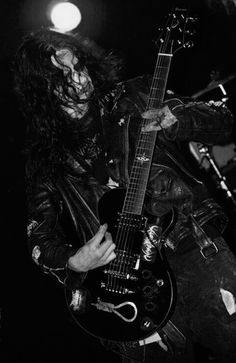 a man with long hair is playing an electric guitar in a black and white photo